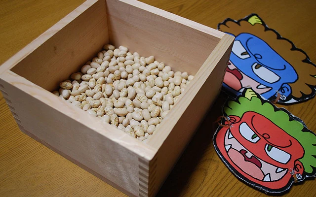 A box with roasted beans (daizu) and two masks of demons (oni), used at the bean throwing ceremony.