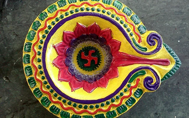 A pottery diya with colorful religious decorating-designs.