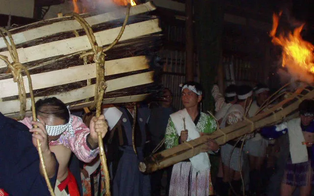 Kurama Fire Parade participants in traditional outfit carrying the big fire torches.