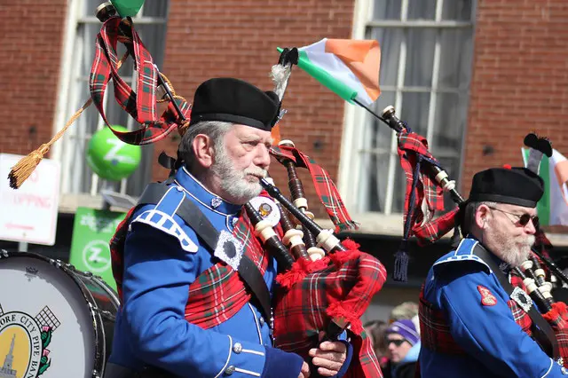 Bagpipe players of a marching band participating on Saint Patrick's parade.