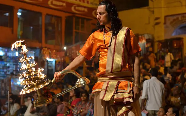 A man holding the Aarti (light in a flame form) worships Goddess Durga.