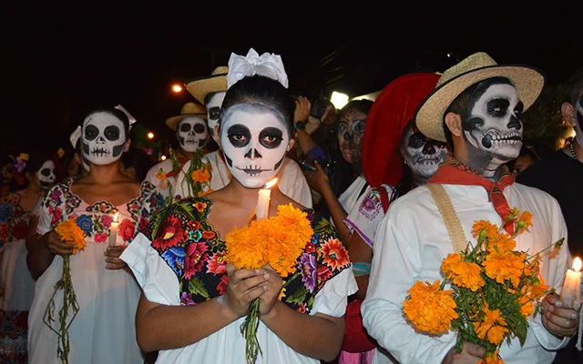 Disguised people (calaveras makeup / traditional clothes) participating in Day of the Dead parade.