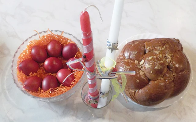 Red dyed eggs, lit candles, and tsoureki (sweet bun) three basic elements of the Greek Easter celebration.