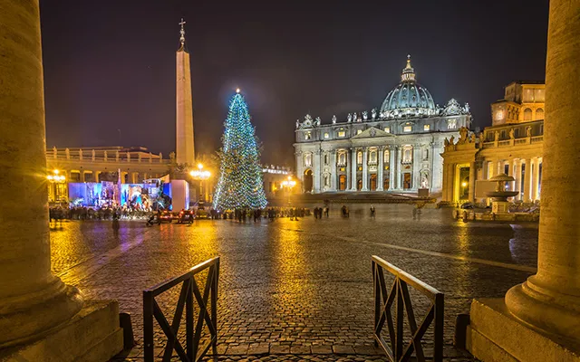 A night vision of the St. Peter's Square with the illuminated Basilica and the decorated tree during Christmas.