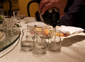 A host fills the glasses with the Baijiu drink.