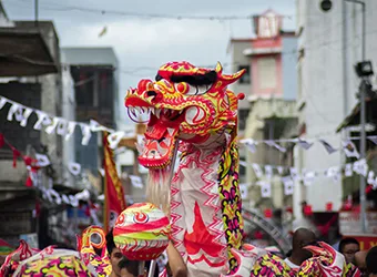 A dragon dance parade through city streets.