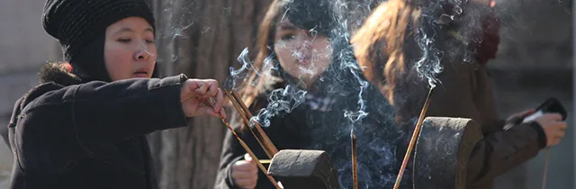 Worshippers offering incense sticks.