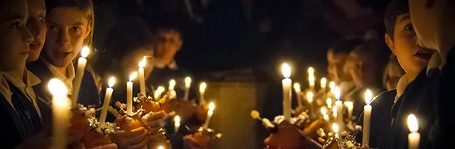 Children with candles in a church during the Christmas vigil.