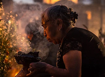 A woman burning incense as part of a ritual.