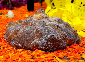 A typically decorated pan de muerto on a table.