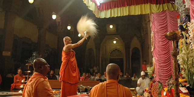 A monk performing a prayer ritual (puja) in front of the idol of Kali during Diwali.