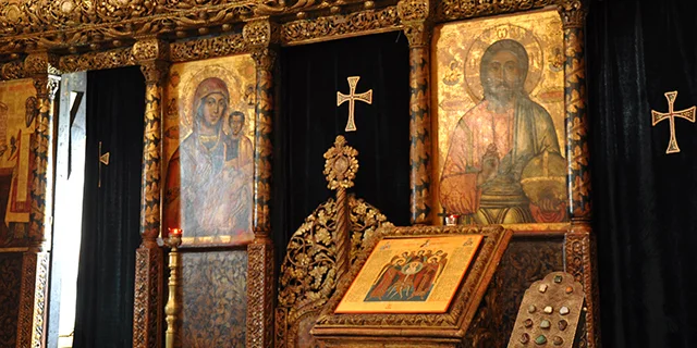Inside an Orthodox church, the gold - icon decorated wooden entrance to the Holy Altar.