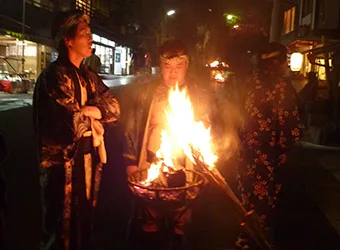 Men in traditional outfits around a bonfire.