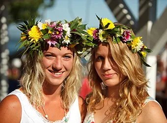 Two girls posing with floral head wreaths.