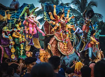 A colorful Durga pandal observed by a crowd.