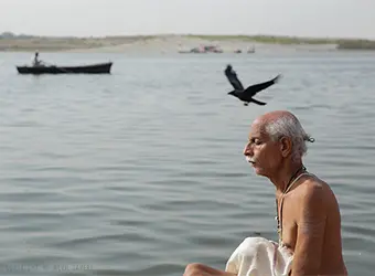 A brahmin is meditating by the river.