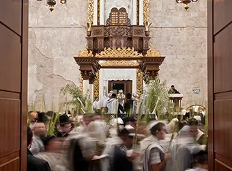 Faithful conducting Sukkot ritual in a synagogue.