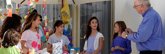 Young children getting instructions on preparing the Sukkah decorations.