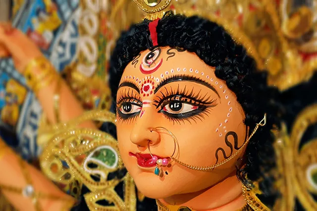 A close up on the face and the eyes of Durga Puja on an idol of the Goddess.