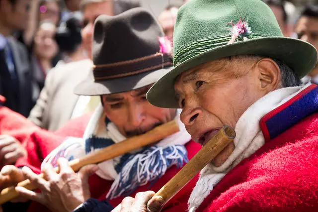 Two men with indigenous origin are playing the flute during Inti Raymi celebrations.