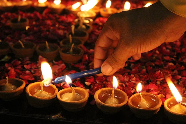 Lighting up diyas (oil lamps) for the Diwali celebration.